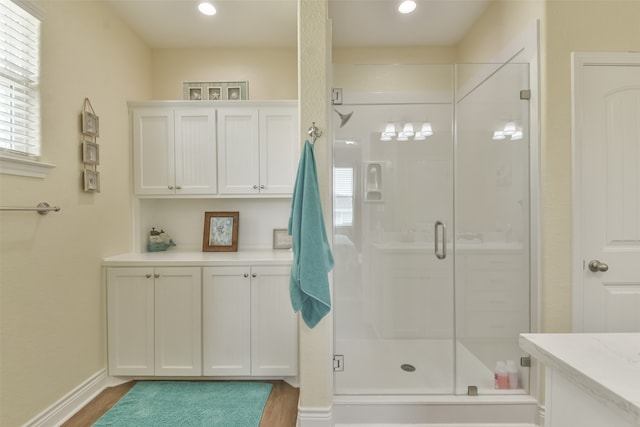 bathroom featuring hardwood / wood-style flooring and a shower with shower door