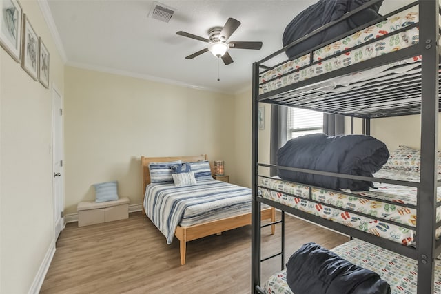 bedroom featuring ceiling fan, ornamental molding, and light hardwood / wood-style floors