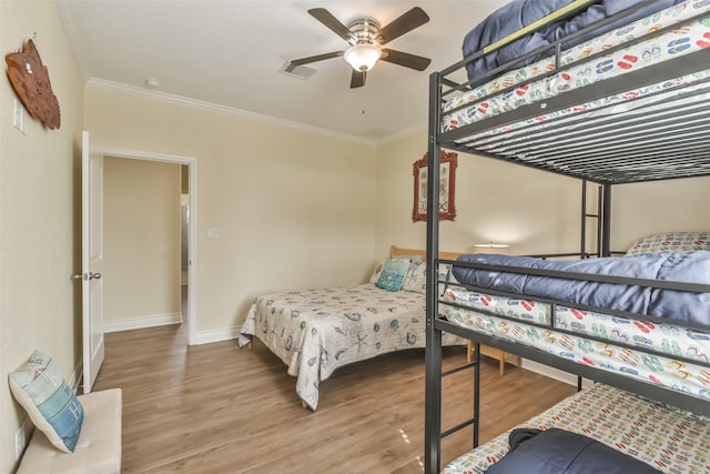 bedroom featuring ceiling fan, crown molding, and wood-type flooring