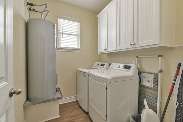 clothes washing area with cabinets, water heater, dark wood-type flooring, and washer and dryer