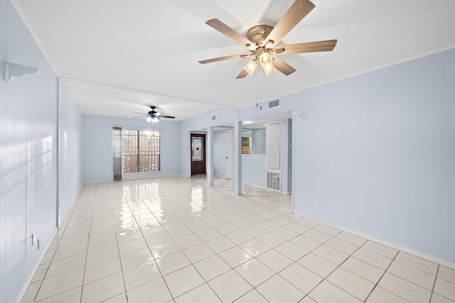 empty room featuring light tile patterned floors, ceiling fan, and crown molding