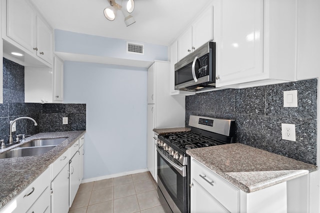 kitchen featuring decorative backsplash, white cabinetry, sink, and appliances with stainless steel finishes