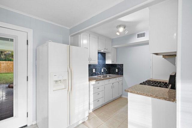 kitchen with white cabinets, sink, white fridge with ice dispenser, ornamental molding, and light tile patterned flooring