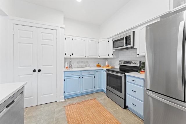 kitchen featuring light tile patterned flooring, white cabinetry, stainless steel appliances, and tasteful backsplash