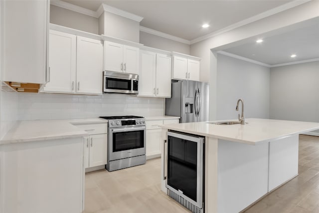 kitchen featuring white cabinetry, appliances with stainless steel finishes, a center island with sink, and beverage cooler