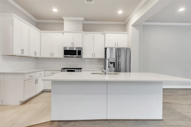 kitchen featuring white cabinets, a kitchen island with sink, stainless steel appliances, and sink