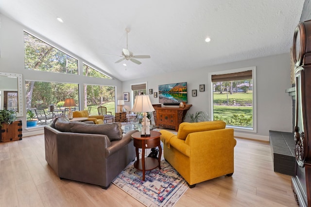 living room with ceiling fan, light hardwood / wood-style floors, and high vaulted ceiling