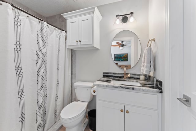 bathroom featuring ceiling fan, vanity, curtained shower, toilet, and a textured ceiling