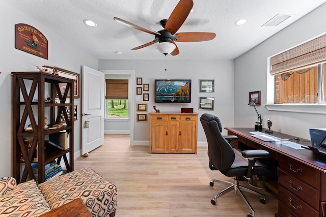 office featuring light wood-type flooring, ceiling fan, and a textured ceiling