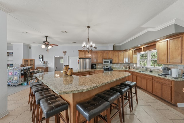 kitchen featuring a breakfast bar area, stainless steel appliances, hanging light fixtures, a large island, and light tile patterned floors