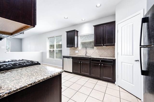 12915 Madison Boulder Ln, Humble, TX 77346 - kitchen with freestanding refrigerator, dishwasher, light tile patterned floors, a sink, and backsplash