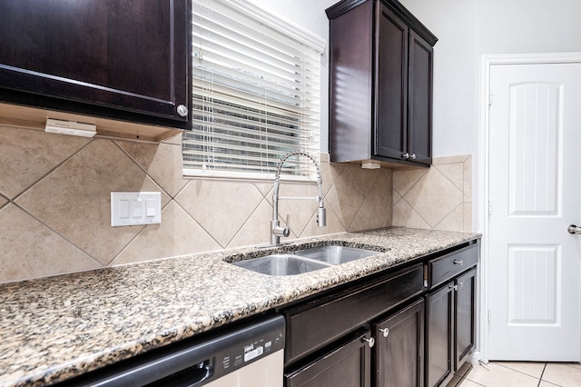 kitchen featuring light stone counters, sink, dark brown cabinets, light tile patterned floors, and backsplash