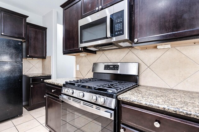 12915 Madison Boulder Ln, Humble, TX 77346 - kitchen featuring dark brown cabinetry, light tile patterned floors, tasteful backsplash, and stainless steel appliances