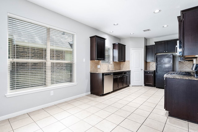 kitchen with decorative backsplash, dark brown cabinetry, appliances with stainless steel finishes, and light tile patterned floors