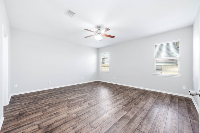 spare room featuring ceiling fan, a wealth of natural light, and dark hardwood / wood-style floors