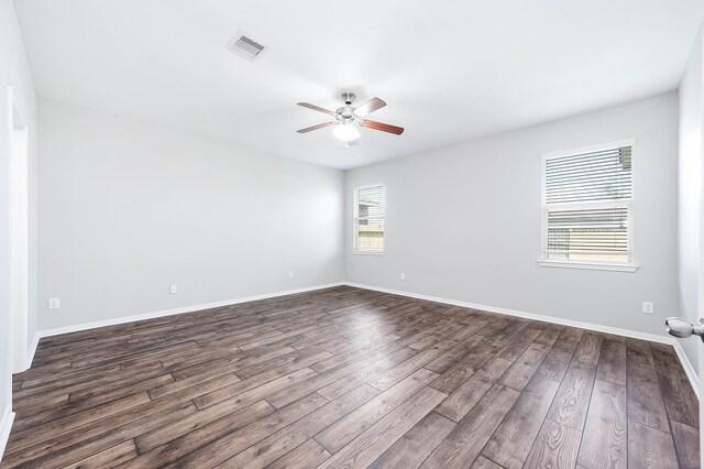 12915 Madison Boulder Ln, Humble, TX 77346 - spare room featuring visible vents, dark wood-style flooring, ceiling fan, and baseboards