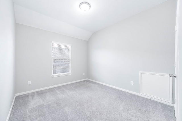 unfurnished room with lofted ceiling and light carpet