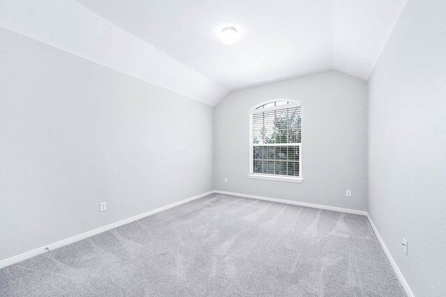 empty room with lofted ceiling and carpet