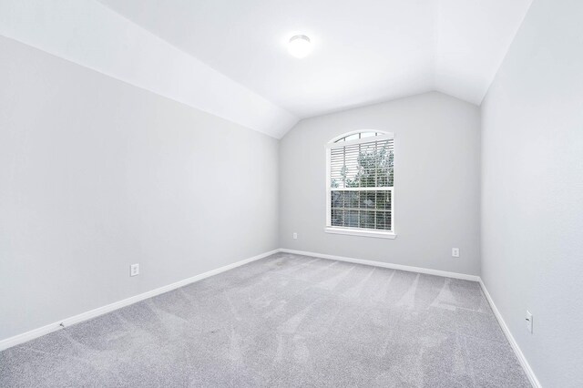 12915 Madison Boulder Ln, Humble, TX 77346 - spare room with carpet floors, baseboards, and vaulted ceiling