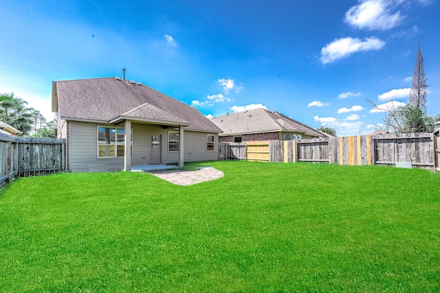 rear view of property featuring a patio and a lawn