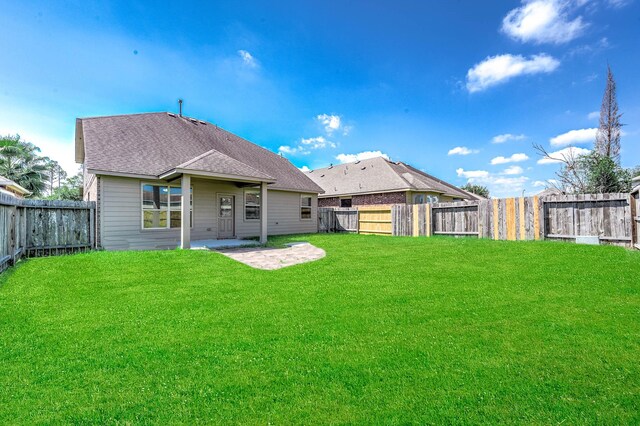 12915 Madison Boulder Ln, Humble, TX 77346 - rear view of property with a patio, a fenced backyard, roof with shingles, and a yard