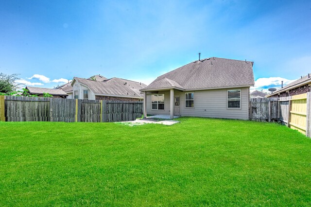 rear view of house featuring a patio area and a lawn