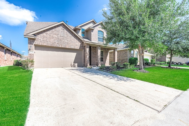 traditional-style home with a garage, driveway, a front lawn, and brick siding
