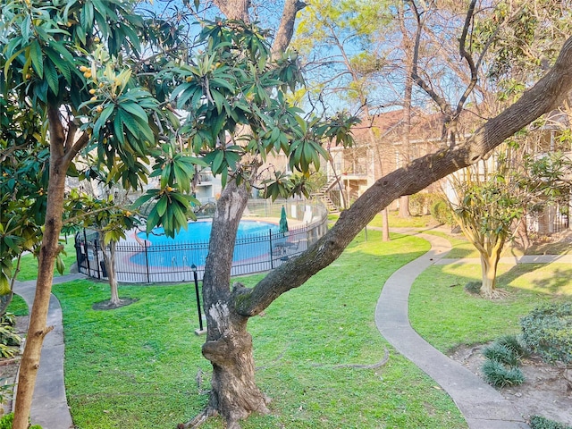 view of home's community featuring a yard and a swimming pool