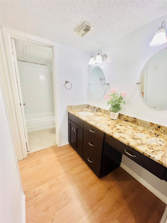 bathroom with toilet, hardwood / wood-style floors, a shower, vanity, and a textured ceiling