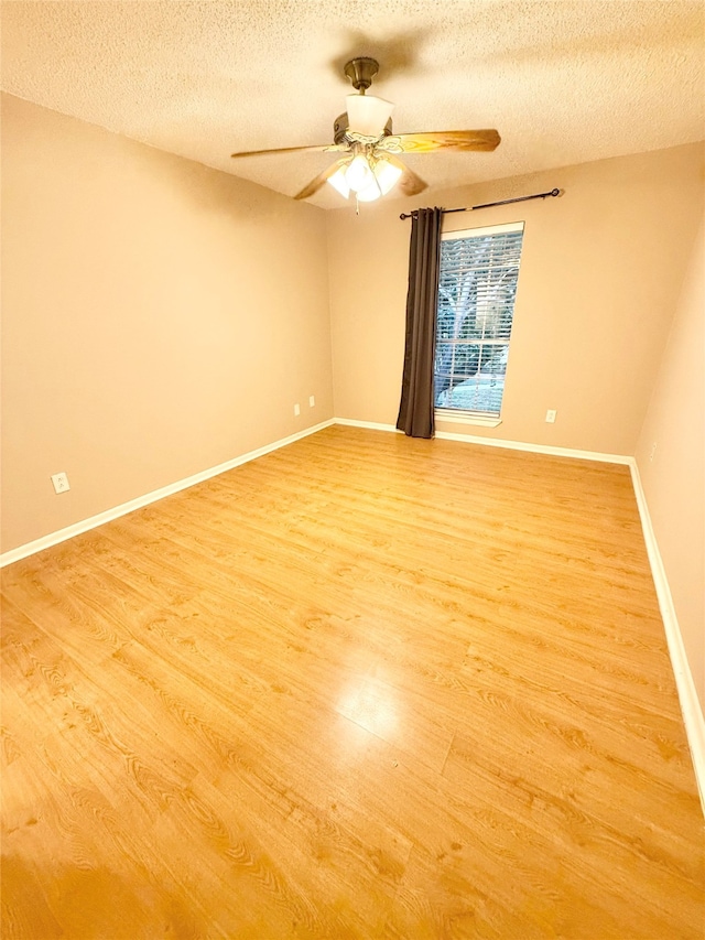 unfurnished room with ceiling fan, wood-type flooring, and a textured ceiling