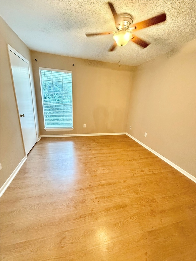 unfurnished room with ceiling fan, hardwood / wood-style flooring, and a textured ceiling