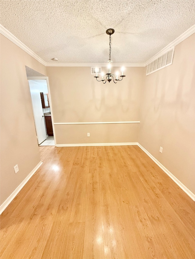 unfurnished dining area with crown molding, wood-type flooring, and a textured ceiling