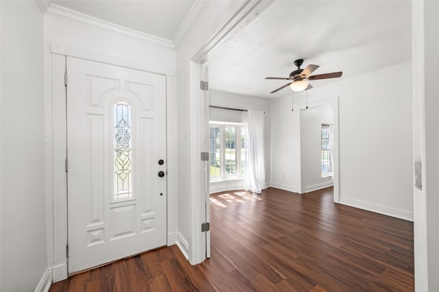 entrance foyer with dark wood-type flooring, ornamental molding, baseboards, and a ceiling fan
