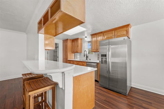 kitchen with stainless steel appliances, kitchen peninsula, dark wood-type flooring, and sink