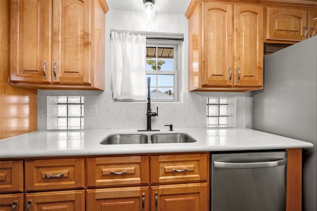 kitchen with backsplash, sink, and stainless steel dishwasher