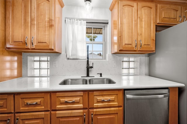 kitchen featuring dishwasher, light countertops, and a sink