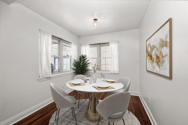 dining space featuring a textured ceiling and hardwood / wood-style floors