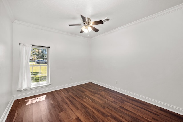 spare room with crown molding, a ceiling fan, visible vents, dark wood-style flooring, and baseboards