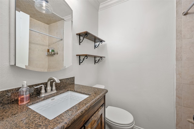 bathroom with crown molding, vanity, toilet, and a tile shower