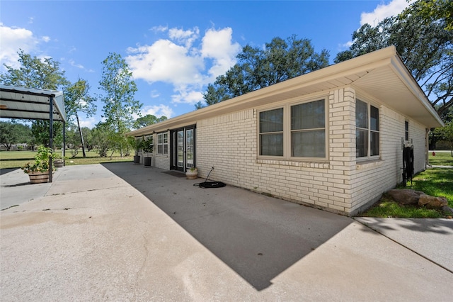 exterior space featuring concrete driveway and brick siding