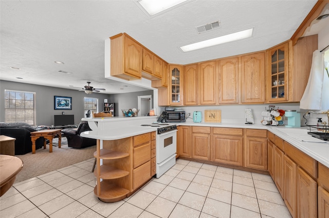 kitchen featuring light colored carpet, a textured ceiling, kitchen peninsula, and white gas range oven