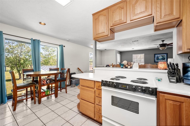 kitchen with light tile patterned floors, light countertops, electric range, and ceiling fan