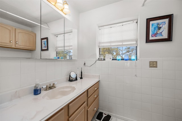 bathroom with vanity, wainscoting, and tile walls