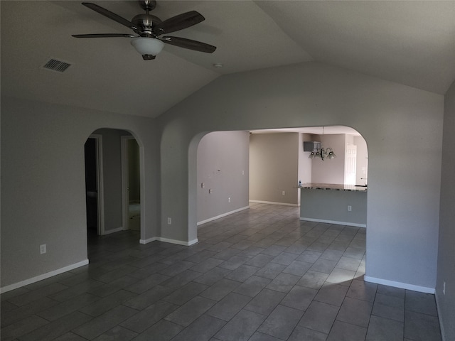 interior space featuring ceiling fan with notable chandelier, vaulted ceiling, and tile patterned floors