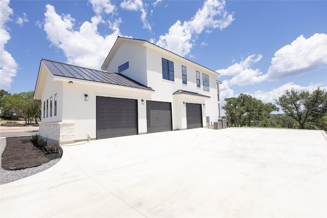 view of side of property with a garage and cooling unit