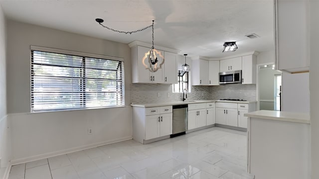 kitchen featuring pendant lighting, tasteful backsplash, a chandelier, white cabinetry, and stainless steel appliances