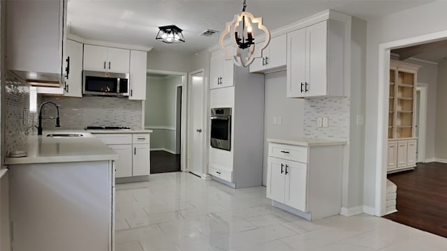 kitchen featuring pendant lighting, stainless steel appliances, backsplash, and white cabinetry