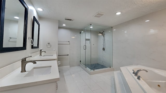 full bathroom with vanity, separate shower and tub, toilet, and a textured ceiling