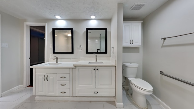 bathroom featuring vanity, toilet, and a textured ceiling