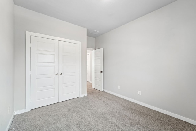 unfurnished bedroom with carpet flooring and a closet